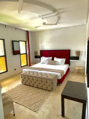 a bedroom with a large bed with a red headboard at Villa Palmyra, 8 suites et piscine chauffée in Marrakech