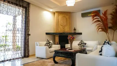 a living room with white furniture and a fireplace at Villa Palmyra, 8 suites et piscine chauffée in Marrakech
