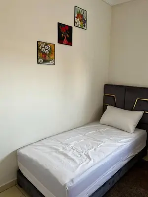 a bed in a room with three pictures on the wall at appartement Marrakech in Oulad Akkou