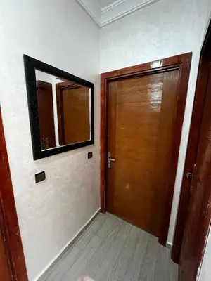 a hallway with a wooden door and a mirror at appartement Marrakech in Oulad Akkou