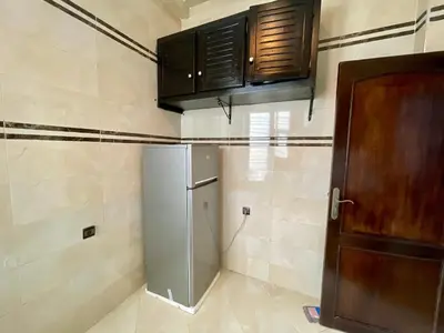 a kitchen with a refrigerator and wooden cabinets at Book your stay at Stay Day apartment in Fez in Fès