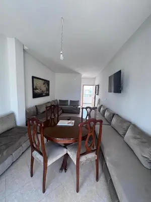 a living room with a table and a couch at RESIDENCE SAIDIA AGDAD ap1 in Oulad Akkou