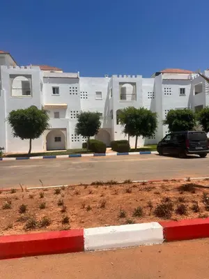 a car parked in a parking lot in front of a building at RESIDENCE SAIDIA AGDAD ap1 in Oulad Akkou