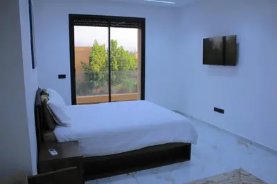 a white bedroom with a bed and a window at Villa house 24 in Najem
