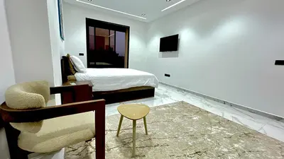 a bedroom with a bed and a chair and a table at Villa house 24 in Najem