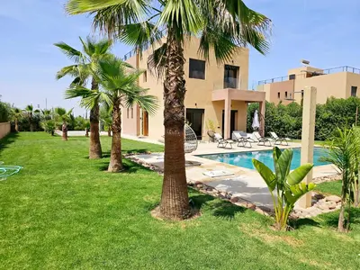 a resort with palm trees and a swimming pool at Villa house 24 in Najem