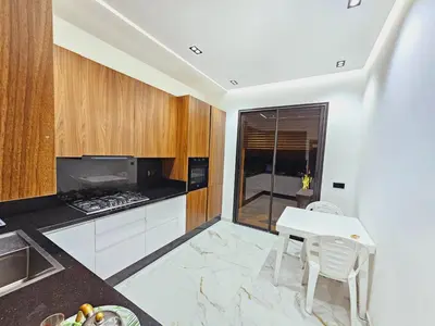 a kitchen with a white table and chairs and a stove at Villa house 24 in Najem
