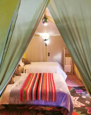a bedroom with two beds in a tent at moon luxury Dessert camp in Merzouga