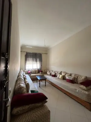 a living room with a long couch and a window at Residence Nassim El Bahre in Oulad Akkou