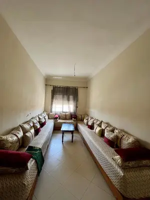 a living room with couches and a window at Residence Nassim El Bahre in Oulad Akkou