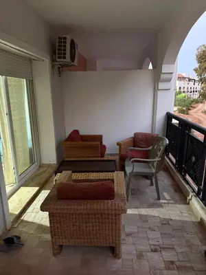 a living room with couches and chairs on a balcony at Le séjour idéal in Oulad Akkou
