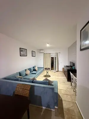 a living room with a blue couch and a table at Le séjour idéal in Oulad Akkou