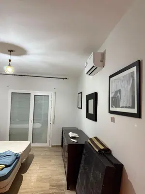 a bedroom with a bed and a desk and a bed at Le séjour idéal in Oulad Akkou