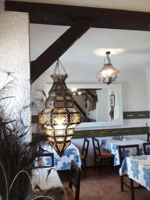 a chandelier in a dining room with a table at Le Gîte Dayet Aoua