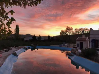 a pool of water with a sunset in the background at Le Gîte Dayet Aoua