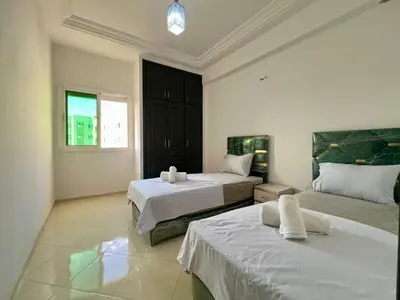 a bedroom with two beds and a window at Diamond Fes Apartment in Fès