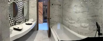 a bathroom with a tub and a sink and a mirror at Oasis Serenity in Oulad Akkou