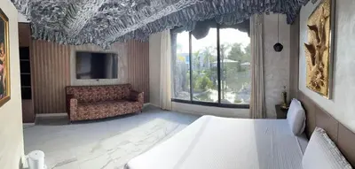 a bedroom with a bed and a chair and a television at Oasis Serenity in Oulad Akkou
