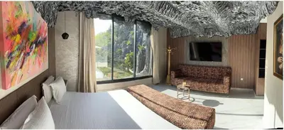 a bedroom with a bed and a couch and a tv at Oasis Serenity in Oulad Akkou