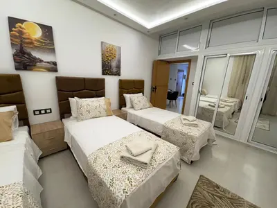 a bedroom with two beds and a mirror at New Design in Today's Style in Oulad Akkou