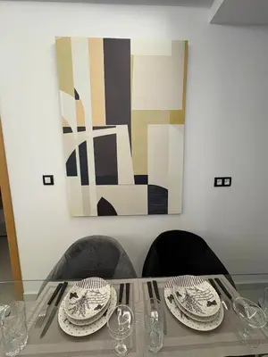 a table with two plates and a painting on the wall at New Design in Today's Style in Oulad Akkou