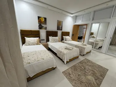 a bedroom with three beds and a mirror at New Design in Today's Style in Oulad Akkou