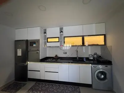 a kitchen with white cabinets and a stove and a refrigerator at New Design in Today's Style in Oulad Akkou