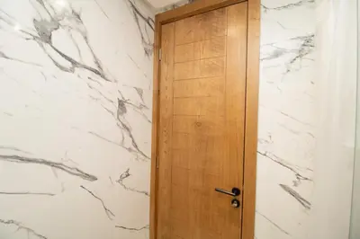 a wooden door in a bathroom with marble walls at Mds1 in Oulad Akkou