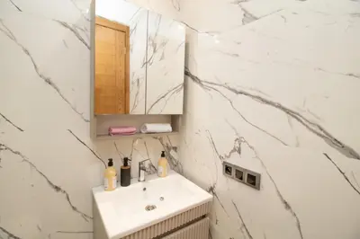 a white bathroom with a sink and a mirror at Mds1 in Oulad Akkou