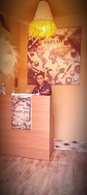 a man standing behind a counter with a sign at DAIFLAH Guesthouse & Hostel