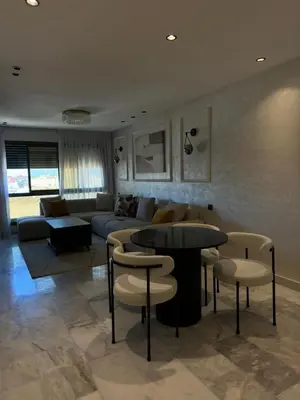 a living room with a couch and a table and chairs at Appartement Studio in Oulad Akkou