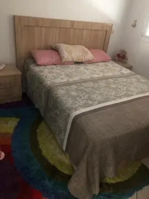 a bedroom with a bed with a wooden headboard at Résidence Nassim al bahr6 in Oulad Akkou