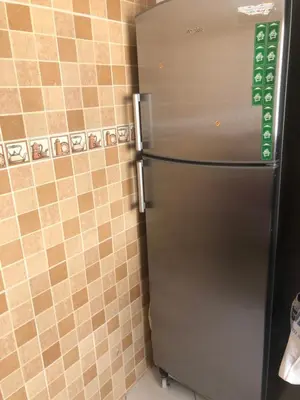 a stainless steel refrigerator in a kitchen with tiled walls at Résidence Nassim al bahr6 in Oulad Akkou