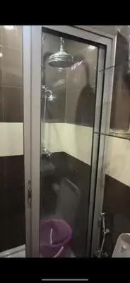 a bathroom with a glass shower with a purple toilet at Samira in Oulad Akkou