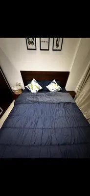 a bedroom with a blue bed with two pillows at Samira in Oulad Akkou
