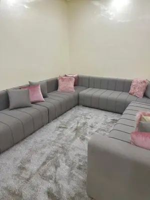 a living room with a gray couch with pink pillows at Samira in Oulad Akkou