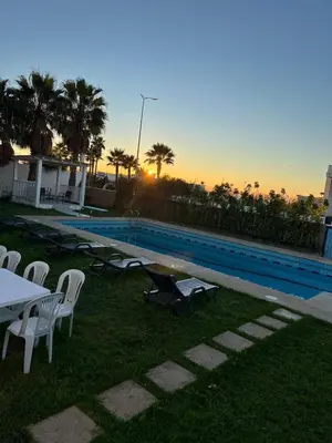 a swimming pool with chairs and a table and a table and a table at Villa Belle Rive Estate in Oulad Akkou