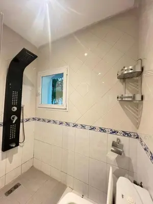a bathroom with a toilet and a window at Villa Belle Rive Estate in Oulad Akkou