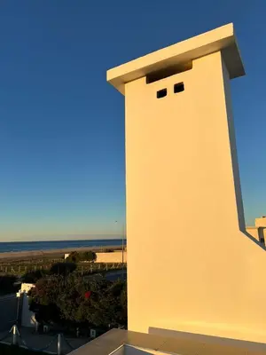 a white building with the ocean in the background at Villa Belle Rive Estate in Oulad Akkou