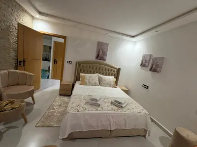 a bedroom with a large bed and a chair at New Design in Today's Style in Oulad Akkou