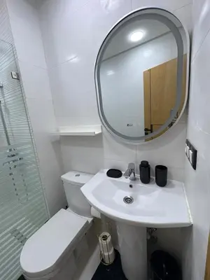 a bathroom with a toilet and a sink and a mirror at New Design in Today's Style in Oulad Akkou