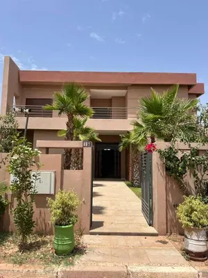 a house with palm trees in front of it at amine amahzoune in Oulad Akkou
