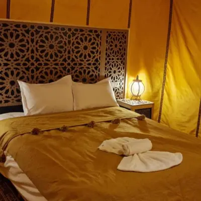 a bedroom with a bed with two towels on it at Luxury camps merzouga in Merzouga