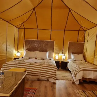 a bedroom with two beds in a tent at Luxury camps merzouga in Merzouga