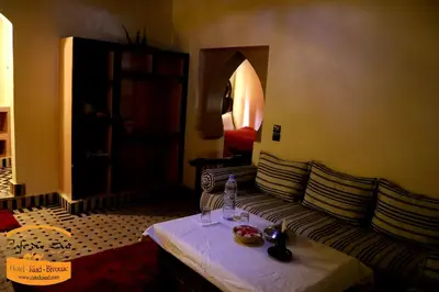 a hotel room with a couch and a table with food on it at Luxury camps merzouga in Merzouga