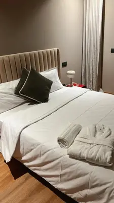 a bed with white sheets and pillows on it at Studio ghandi in Oulad Akkou