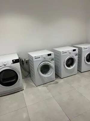 three washing machines and a washer and dryer in a room at Studio ghandi in Oulad Akkou