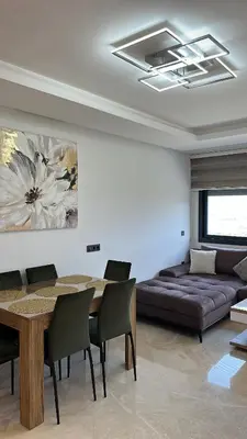 a living room with a table and a couch at New luxury appartement in Oulad Akkou