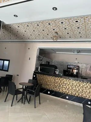 a restaurant with a counter with chairs and a table at Cafe Restaurant Moove Oil in Rissani