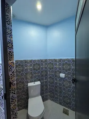 a bathroom with a toilet and a blue light at Cafe Restaurant Moove Oil in Rissani